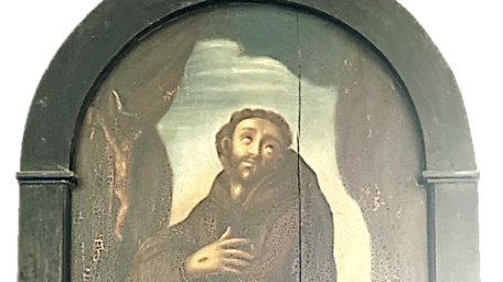 Franz von Asissi (1181/82 – 1226), mit den Attributen braune Kutte des Franziskanerordnens, Wundmalen (Stigmata) an der rechten Hand, Totenkopf in der linken Hand, Kruzifix links im Hintergrund. Barockes Ölgemälde auf Holz im Kreuzgang des ehem. Kapuzinerklosters Bacharach.
